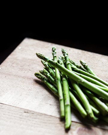 Bunch of fresh green asparagus spears on a rustic wooden tableの写真素材