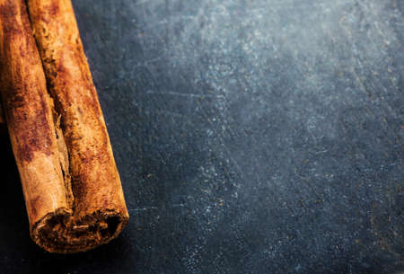 Bunch of cinnamon sticks close up on dark background with blank copyspace for your text