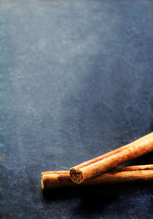Bunch of cinnamon sticks close up on dark background with blank copyspace for your textの写真素材