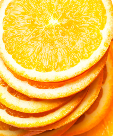 Slices of fresh orange fruit  isolated on white background closeup. Stack of orange slicesの写真素材