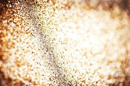 Holiday abstract glitter background with blinking lights and gold defocused texture. Golden Glitter festive bokehの写真素材