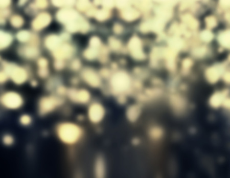 Defocused Bokeh twinkling lights - Glitter Abstract circular bokeh background of Christmas light. Golden and black Vintage background.の写真素材