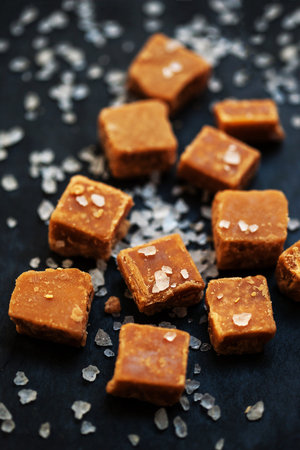 Sweet treats - Salted caramel pieces and sea salt close up.の写真素材