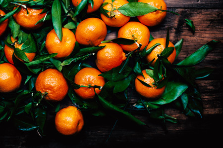 Tangerines with leaves on wooden background. Mandarins Tangerine Closeup. Rustic styleの写真素材