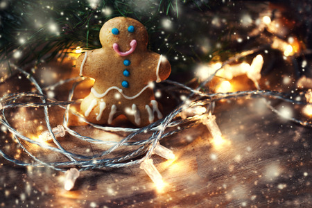 Christmas homemade gingerbread man cookie on wooden table with decorations. Christmas Holiday...