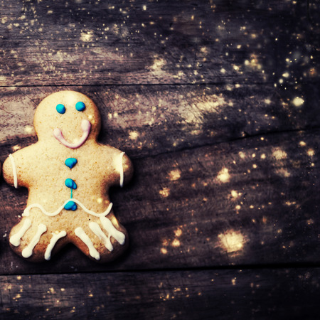 Christmas homemade gingerbread man cookie on wooden table with decorations. Christmas Holiday...