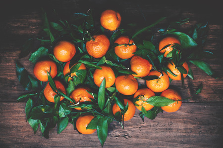 Tangerines with leaves on wooden background. Mandarins Tangerine Closeup. Rustic styleの写真素材