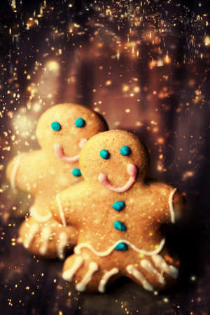 Christmas homemade gingerbread cookies over wooden table. Christmas Card with decorations and...