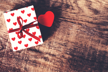 Valentines Day background with red heart and present gift on wooden background with blank copy spaceの写真素材