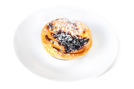 Egg tart or portuguese egg tart on white plate isolated on white background close up