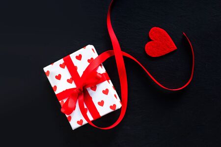Valentines day gift box and red heart on dark background with copyspaceの写真素材