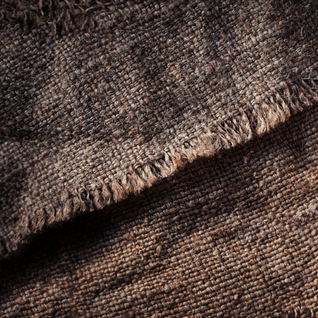 Old wooden  table with sack cloth  in dark interior with copy space. Burlap textureの写真素材