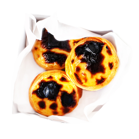 Pastel de Nata - creamy sweet curstard with black crust and sugar powder isolated on white. Pasteis...
