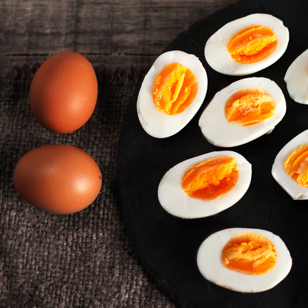 Halved  Eggs on wooden  background closeupの写真素材