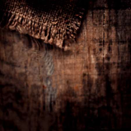 Old wooden  table with sack cloth  in dark interior with copy space. Burlap textureの写真素材