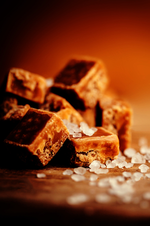 Toffees. Caramel pieces with copy space for your design over dark wooden background  close up image.の写真素材