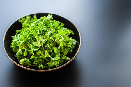 Fresh green kale salad leaves in a bowlの写真素材