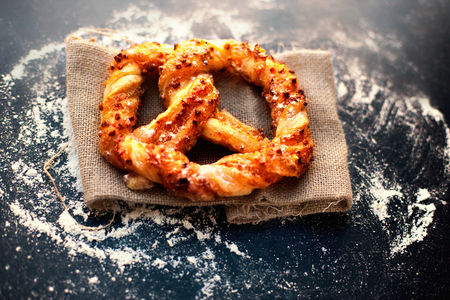 Delicious Fresh  pastry on dark background with flour.  Sweet pretzels with powdered sugar.  Closeup...