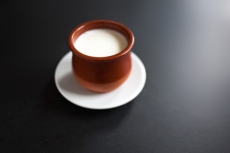 Sour  cream or natural  Cottage cheese curd  in traditional ceramic bowl on dark  background....