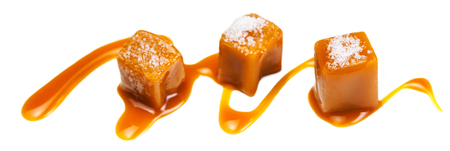 Caramel candies and caramel sauce isolated on a white background. Golden Butterscotch toffee candyの写真素材