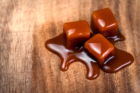 Organic caramel candies and caramel sauce on wooden table, Golden Butterscotch toffee caramels
の写真素材