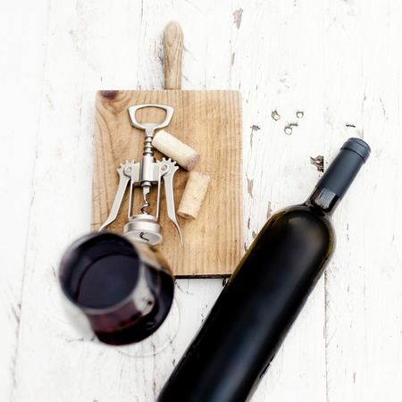  A glass of red wine, bottle, corkscrew  and wine corks on rustic white wooden background, copyspsce. Wine tasting concept
の写真素材