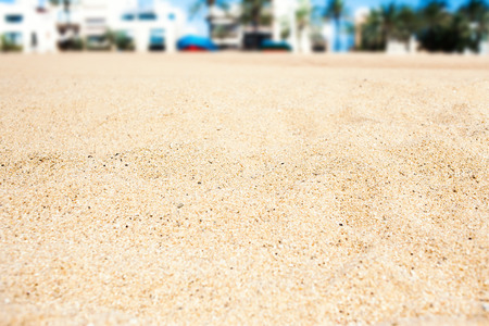 Empty summer beach scene with city on background - tropical vacation and travel concept. Sand textureの写真素材