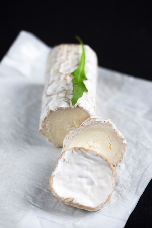 Stick of a goat cheese on black stone background. Fresh goat cheese with copy spaceの写真素材