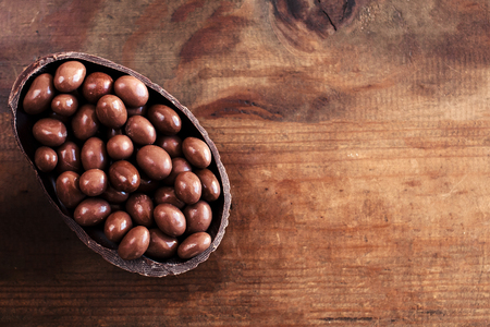 Chocolate Halved  Easter eggs on wooden background with chocolate candies, copy spaceの写真素材