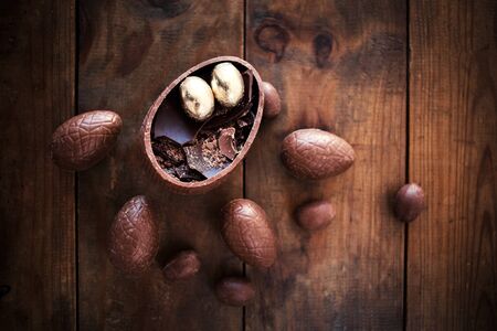 Chocolate Easter eggs on wooden background with ribbon bow and candies. Happy Easter!
の写真素材