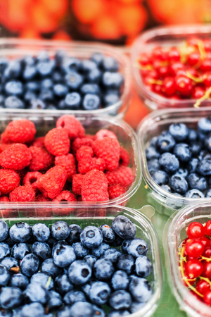 Various berries from a local farmer market.  Healthy local food market concept. Variety of berries in a box -  blackberry, raspberry, strawberry, cherry
の写真素材