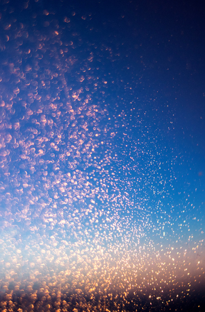 Glitter lights abstract background. Golden Sparkle stardust on blue and black defocused texture.の写真素材