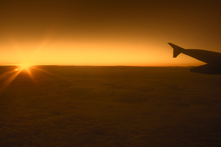 View from airplane window on the wing during  sunset over the clouds. Business trip. Travel conceptの写真素材