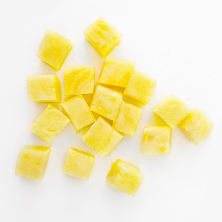 Fresh pineapple cube slices isolated on the white background. Pineapple chunks close upの写真素材