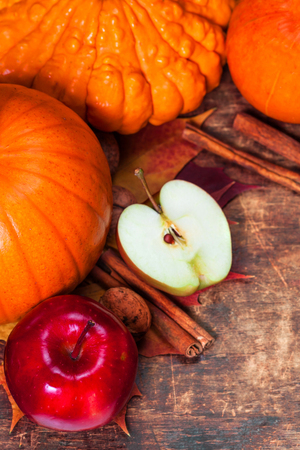 Harvest or Thanksgiving background with pumpkins, apples and fallen leaves on wooden background  with copyspace. Halloween, Thanksgiving day or seasonal autumnal conceptの写真素材