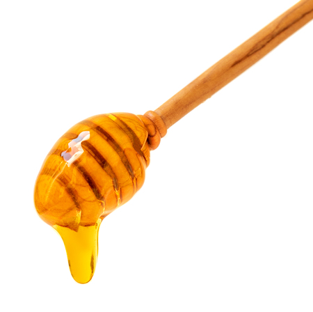 Wooden dipper with dripping honey isolated on white background, macroの写真素材