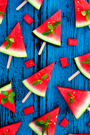 Watermelon pattern. Sliced watermelon   on  blue rustic wooden background. Flat lay. Tropical Summer ideaの写真素材