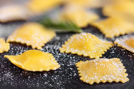 Raviolli with flour and herbs on black background, close up.  Italian Foodの写真素材