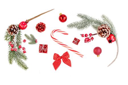Christmas composition Isolated. Christmas  pine branches with red berries, balls, gifts and sweet cane on white background. Creative layout. Flat lay, Top view.の写真素材