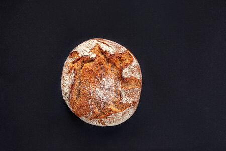 Sourdough Bread  on black background. Freshly baked bread close up. Top view. Copy space. Food concept.の写真素材