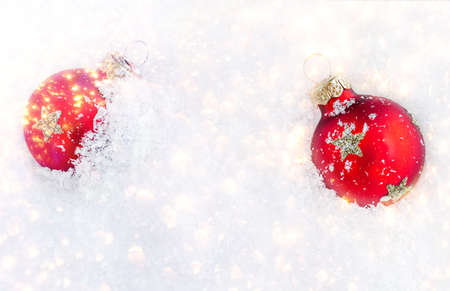 Christmas ornaments on snow with copy space. Glossy red balls top view.の写真素材