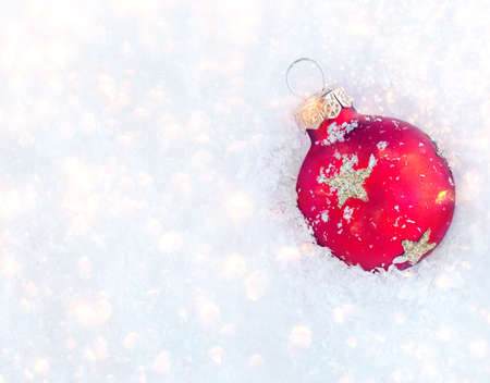 Christmas ornaments on snow with copy space. Glossy red balls top view.の写真素材