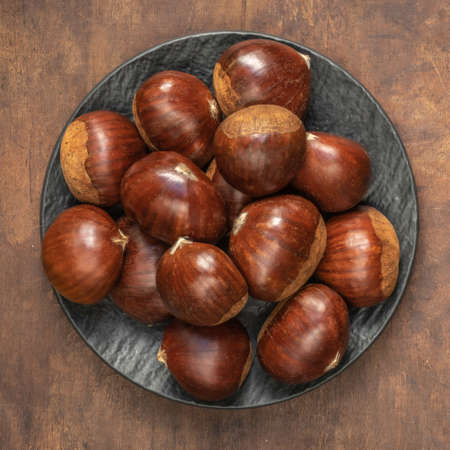 Chestnuts on on an old board with copy space. Autumn mood. Horse chestnuts top viewの写真素材
