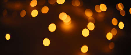 Christmas dark glowing Golden Abstract Background. Blurred Xmas Bokeh lightsの写真素材