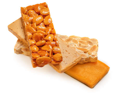 Turron nougat - traditional almond and caramel dessert isolated on white background. Christmas turron candyの写真素材