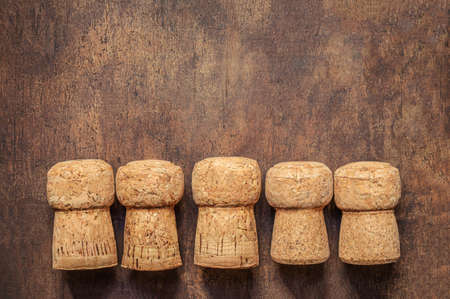 Wine corks closeup on a wooden table. Five wine corks in a row with copyspace. Top view. Flat layの写真素材