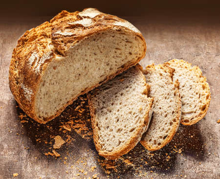 Freshly baked round Bread on dark wooden background. Bakery, rustic traditional food concept. Top viewの写真素材
