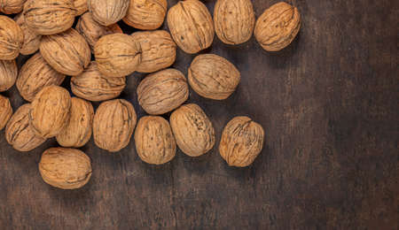 Walnuts on dark vintage table. Walnuts kernels with green leaves. Copyspace.の写真素材