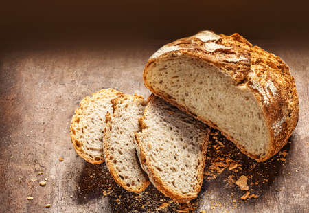 Wholegrain Bread on dark wooden background. Bakery, rustic traditional food concept. Top viewの写真素材