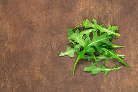 Ruccola leaf on wooden table, pile of fresh green arugula leaves collection top view.の写真素材